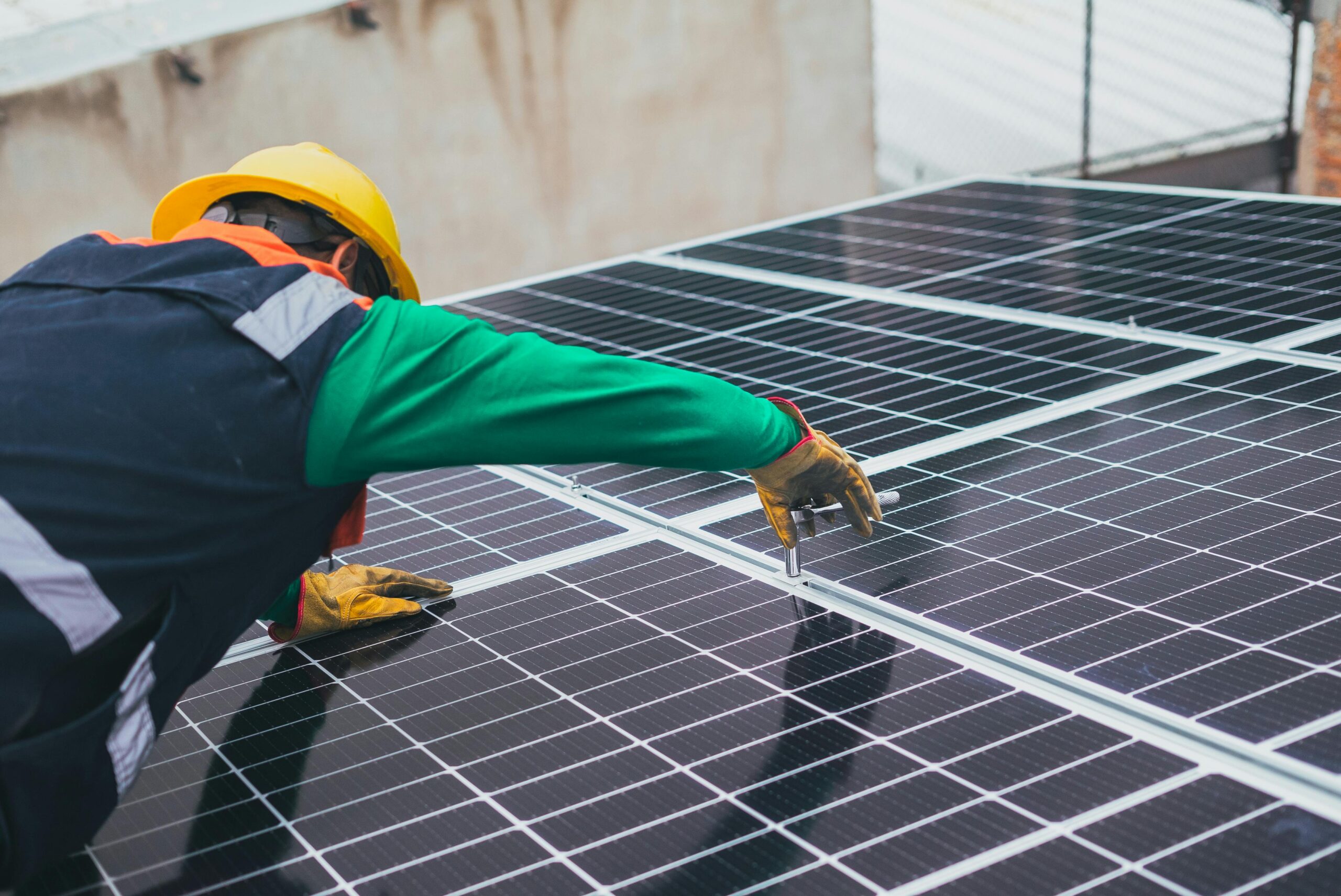 Technician installing solar panels on a rooftop for sustainable energy solutions.